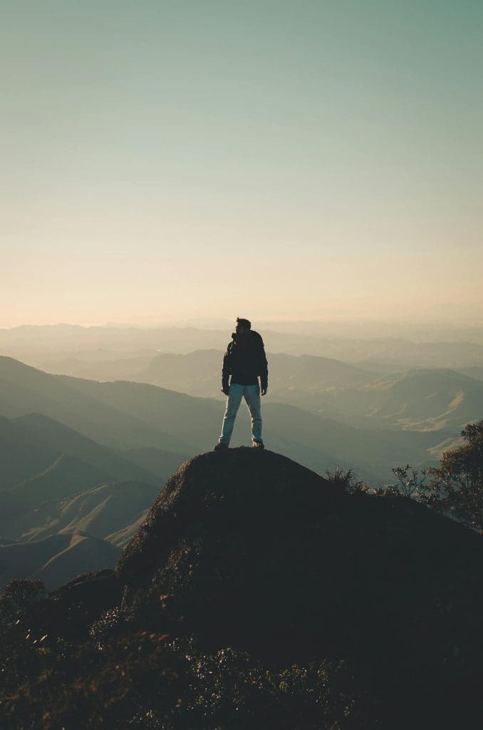 A man enjoys a breathtaking view from a mountain peak, embracing freedom and adventure.